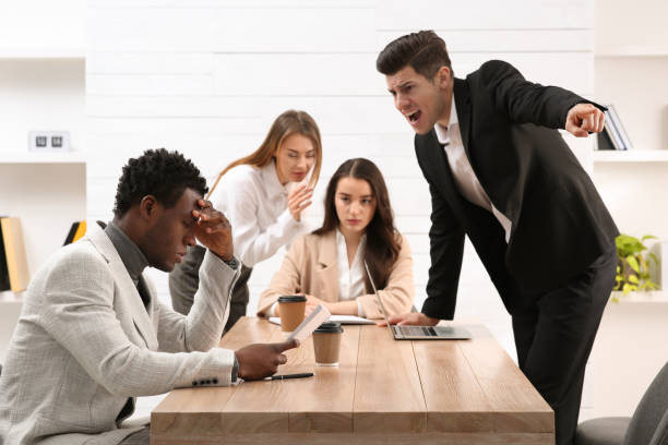 Man screaming at African American coworker in office. Racism concept Man screaming at African American coworker in office. Racism concept pain points stock pictures, royalty-free photos & images