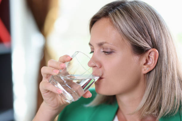 istock Thirsty woman drinking water from transparent glass 1445182034