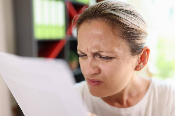 istock Focused woman trying read papers, squinting to see more clearly 1445182036