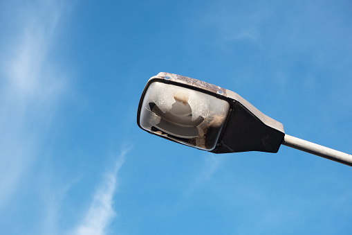 close up of old and broken street lamp isolated on clear sky background