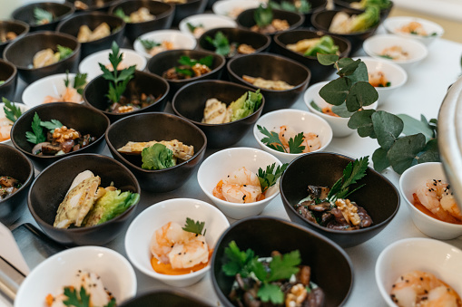 black and white bowls with appetizers and fish and shrimp variations at the buffet