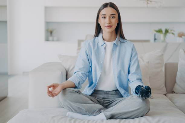 istock Disabled girl with bionic prosthetic arm does yoga, sitting in lotus pose. Disability, stress relief 1445187350