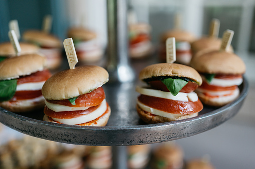 mini veggie burger with tomato, mozzarella and basil on a buffet etagere
