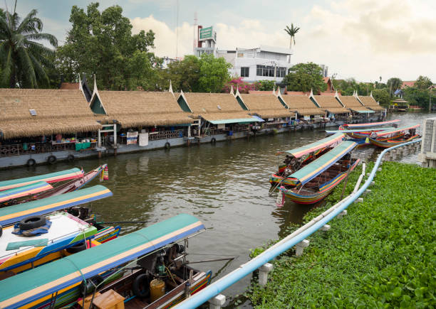 Damnoen Saduak, Thailand - July 22, 2011: Vendors and tourists at Damnoen Saduak floating market in Thailand. The Market is held everyday until noon and has become very popular with tourists visiting from Bangkok