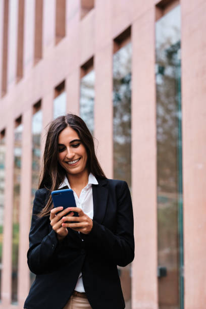 istock Businesswoman using a mobile outdoors 1445188403