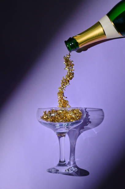 Pouring Champagne Wine in Glass From Bottle stock photo
