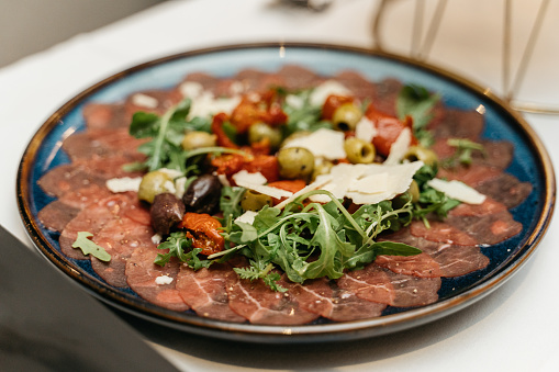 beef carpaccio with dried tomatoes, olives and parmesan cheese