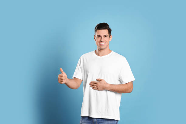 istock Happy healthy man touching his belly on light blue background 1445190243
