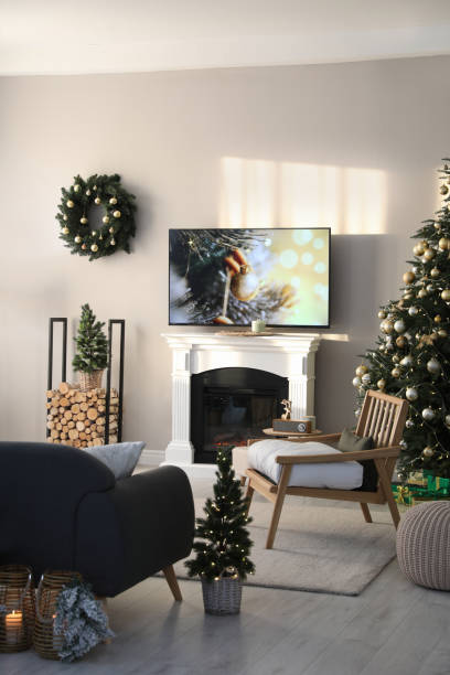 istock Modern TV set on light wall in room decorated for Christmas 1445191376