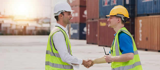 Caucasian business managers and worker team is meeting do shake hands on a large commercial tracking inventory, close up. Business Partnership Greeting Handshaking to seal the deal After Discussion.
