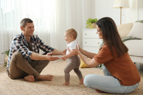 istock Parents supporting their baby daughter while she learning to walk at home 1445193020