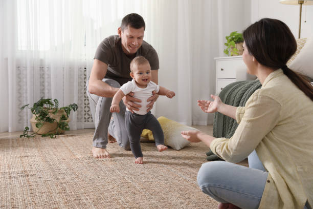istock Parents supporting their baby daughter while she learning to walk at home 1445193256
