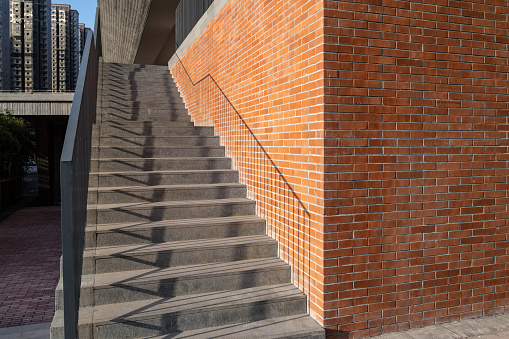 Outdoor staircase beside red brick wall