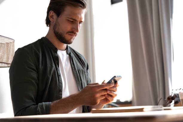 istock Young employee at workplace using mobile phone, checking social media on smartphone, taking break, copy space. 1445196715