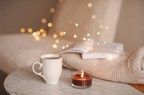 istock Cup of tea with candle over lights 1445196864
