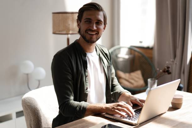 istock Male remote working from home and having work confrence video call. Freelancer working on laptop at home office. 1445197218