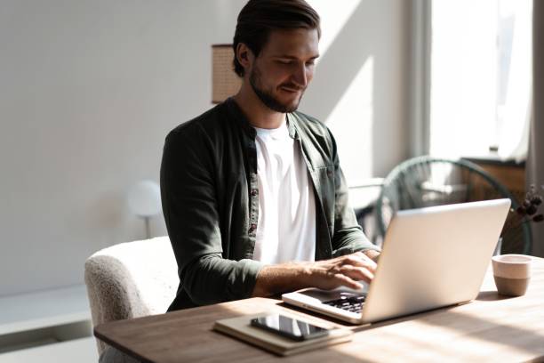 istock Male remote working from home and having work confrence video call. Freelancer working on laptop at home office. 1445197226
