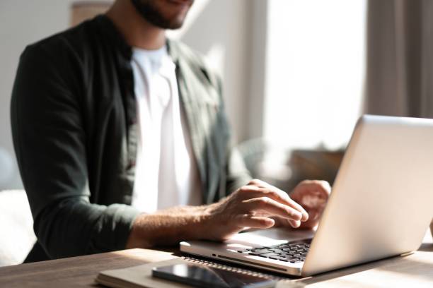 istock Male remote working from home and having work confrence video call. Freelancer working on laptop at home office. 1445197234