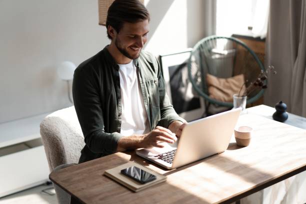 istock Male remote working from home and having work confrence video call. Freelancer working on laptop at home office. 1445197242
