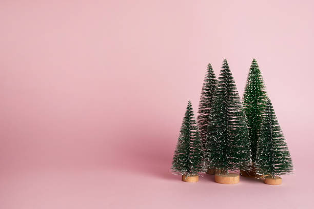 istock Christmas trees on pastel pink background. Minimal holiday concept. New year simple composition. Merry Christmas and happy New Year greeting card 1445199499