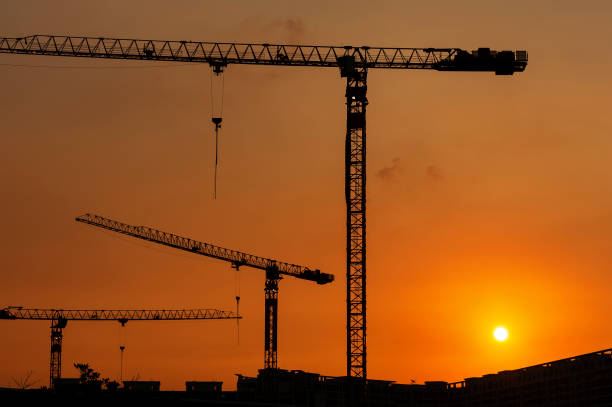 istock Silhouette of crane in construction site under sunset 1445200845