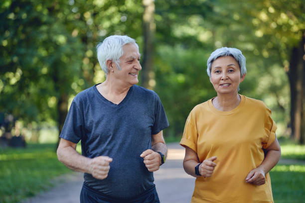 istock Older couple jogging in the summer park 1445202079