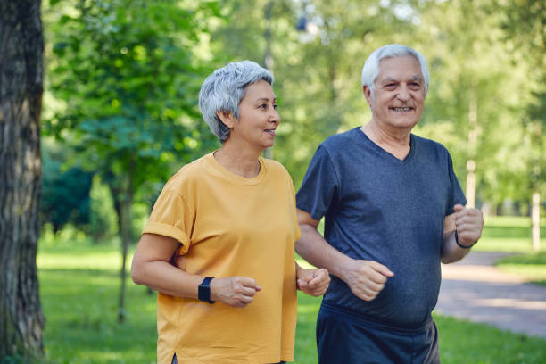 istock Older couple jogging in the summer park 1445202089