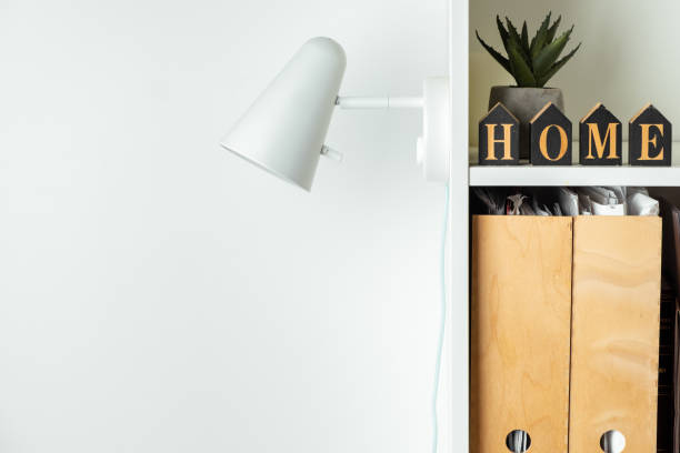 istock White wall lamp on white wall background. Saving energy. Living during blackout concept. Copy space for a free text. Mockup for Scandinavian interior design project. Stylish book shelf design 1445203907