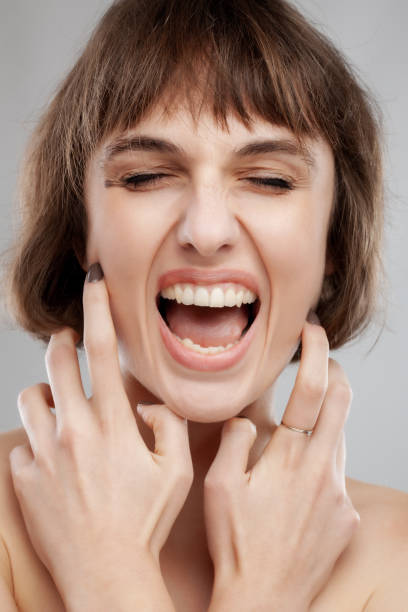 portrait de beauté d’une fille brune à la coiffure courte. crier et faire des expressions faciales avec la bouche ouverte - mouth open women displeased anger photos et images de collection