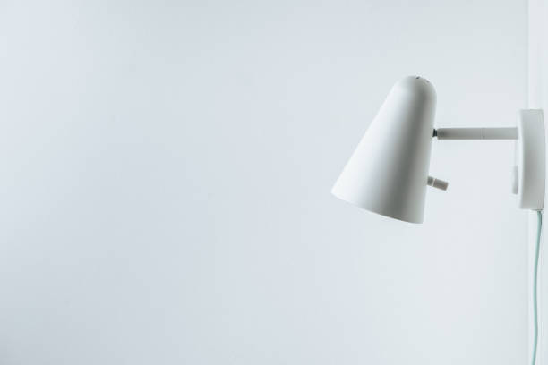 istock White wall lamp on white wall background. Saving energy. Living during blackout concept. Copy space for a free text. Mockup for interior design project 1445203939
