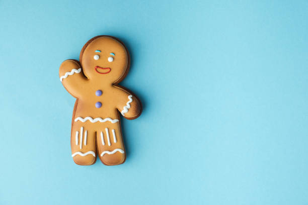 istock Gingerbread man decorated with white icing isolated on the blue pastel background. Flat lay. Traditional homemade Christmas cookies. Copy space 1445204114