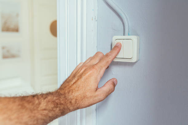 istock Male hand pushing old retro light switch in living room 1445205513