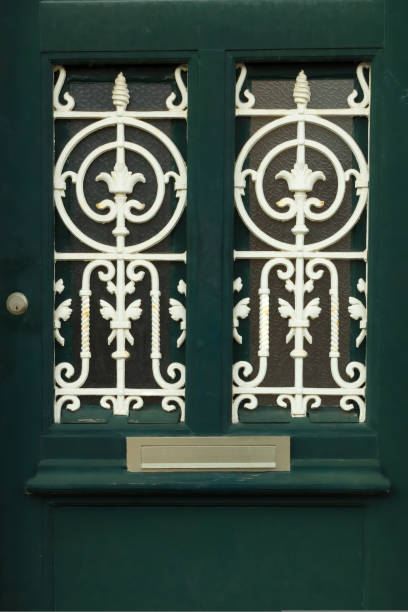 Details of green front door with art nouveau ironwork, Utrecht, the Netherlands Close-up of a green painted wooden front door with art nouveau or art deco ironwork, lock and letterbox, Utrecht, Netherlands art nouveau ironwork stock pictures, royalty-free photos & images