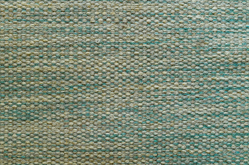 Woven carpet mat flooring pattern as background, top view