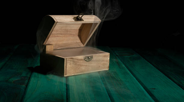 istock Empty wooden treasure box on green table with smoke all around 1445207501