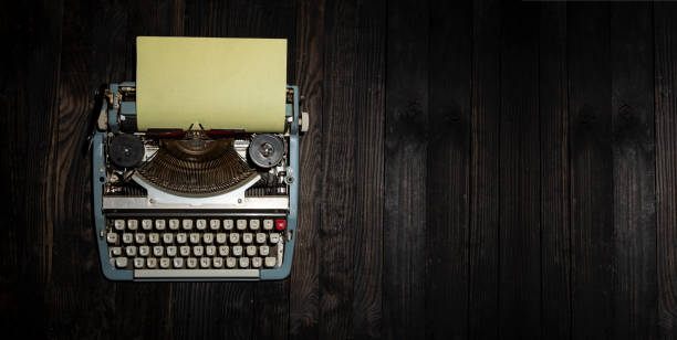 istock Old typewriter with paper on dark wooden table with copy space of banner 1445207529