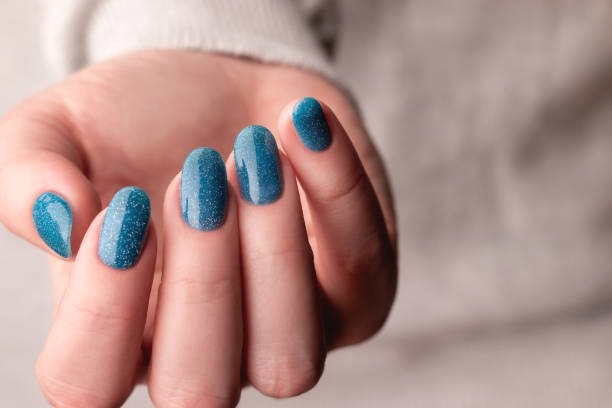 istock Female hand with blue glitter nails 1445210914