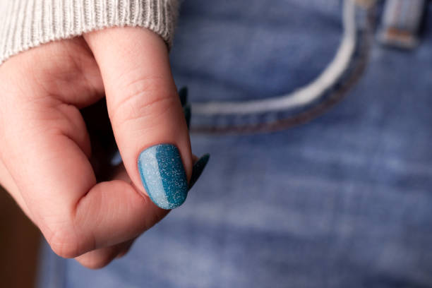 istock Female hand with blue glitter nails on jeans 1445211101