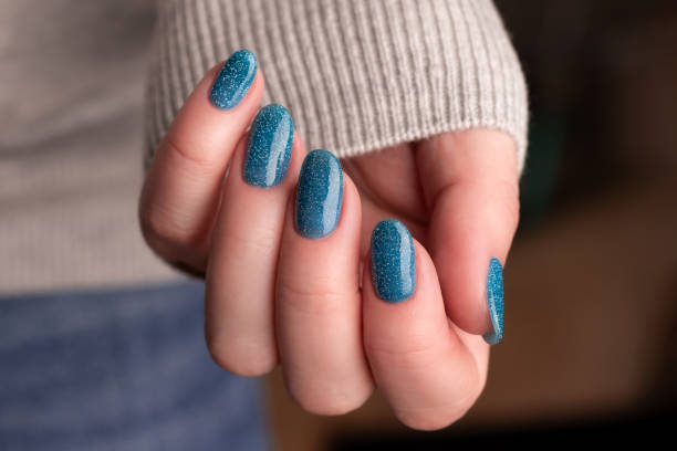 istock Female hand with blue glitter nails 1445211167