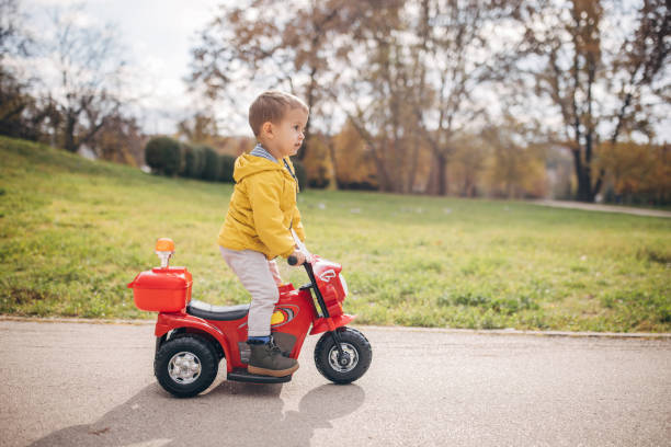 istock Little boy riding toy motorcycle in park 1445212493