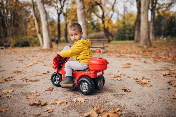 istock Little boy riding toy motorcycle in park 1445212571
