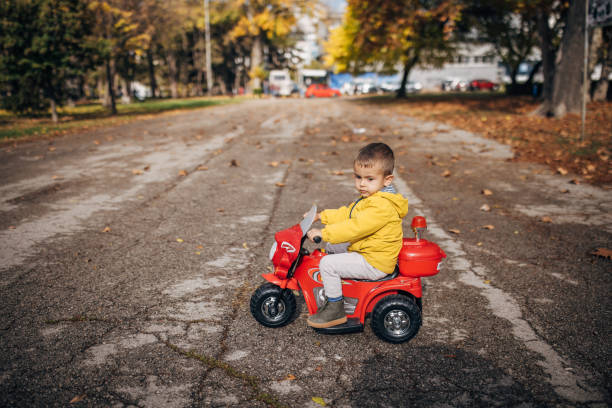 istock Boy riding toy motorcycle in park 1445212692