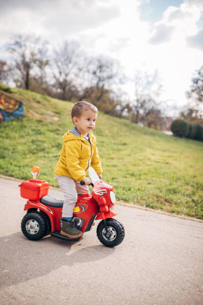 istock Little boy riding toy motorcycle in park 1445212747