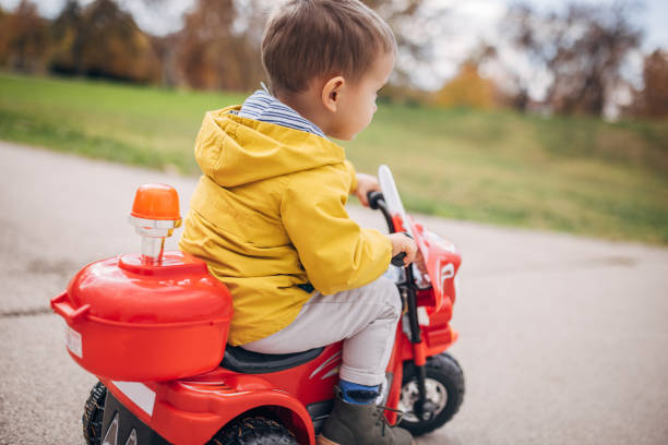 istock Little boy riding toy motorcycle in park 1445212771