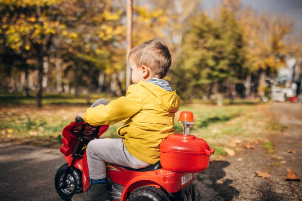 istock Boy riding toy motorcycle in park 1445212871