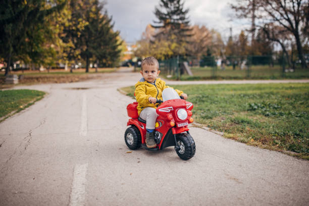 istock Boy riding toy motorcycle in park 1445212899