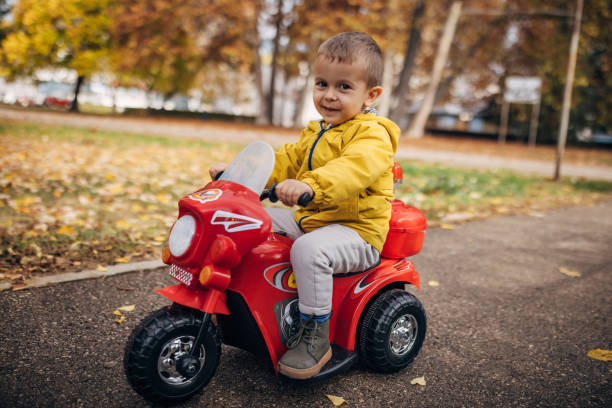 istock Boy riding toy motorcycle in park 1445212937
