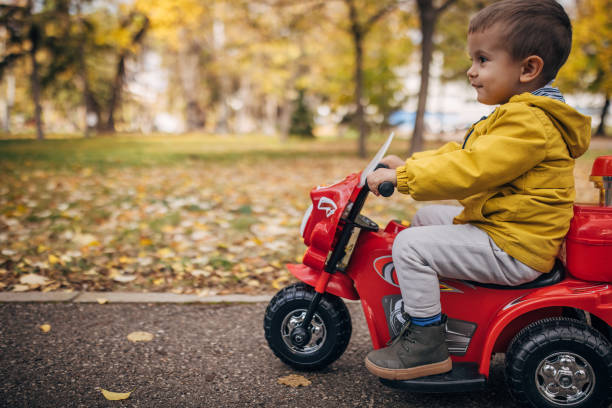 istock Boy riding toy motorcycle in park 1445212972