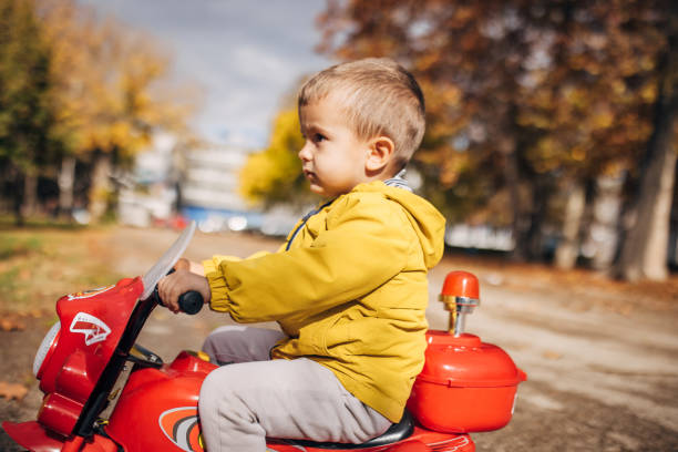 istock Boy riding toy motorcycle in park 1445212996