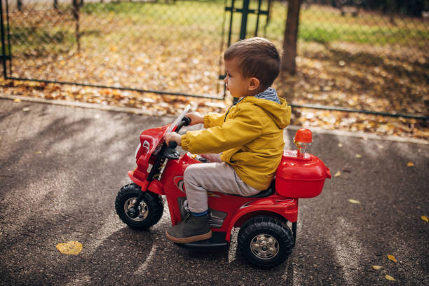 istock Boy riding toy motorcycle in park 1445213088